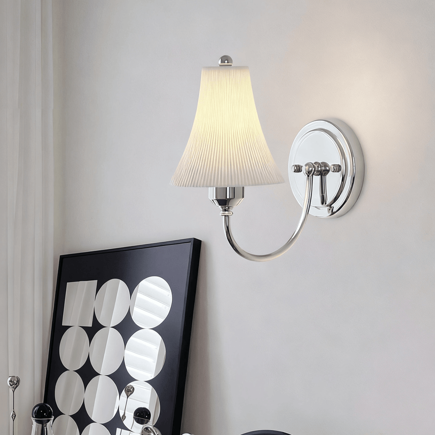 The sconce lit above a print with a pattern of white circles