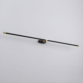 The black and gold rod seen at an angle, a thin line against a pale wall