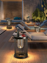 A run of lanterns lit along a terrace beside two sun loungers at dusk