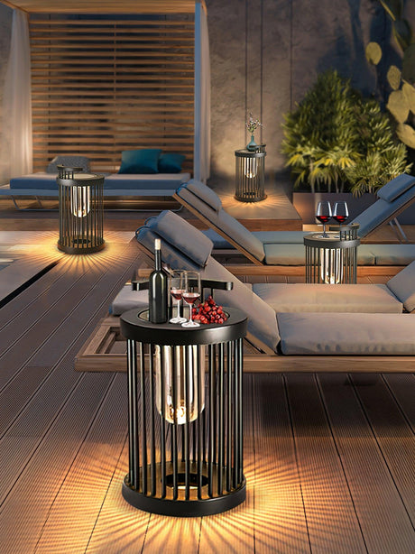 A run of lanterns lit along a terrace beside two sun loungers at dusk