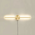 The taller gold profile lit on a pale wall, the cord dropping below the plate