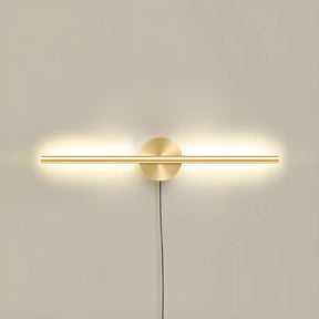 The taller gold profile lit on a pale wall, the cord dropping below the plate