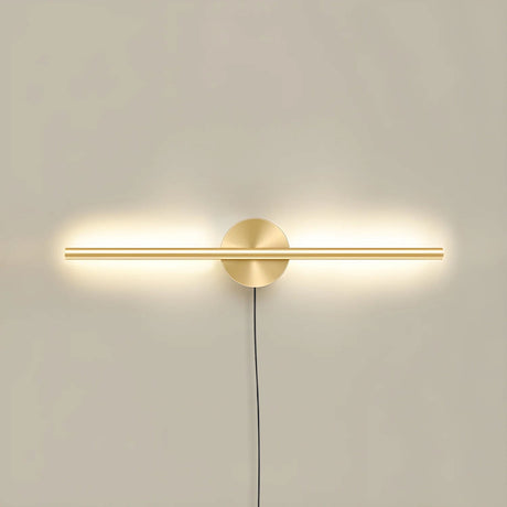 The taller gold profile lit on a pale wall, the cord dropping below the plate