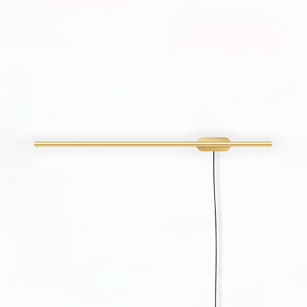 Slim gold bar crossing a round plate with a braided cord dropping down the wall