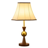 Walnut stem and brass sphere under a plain cream empire shade