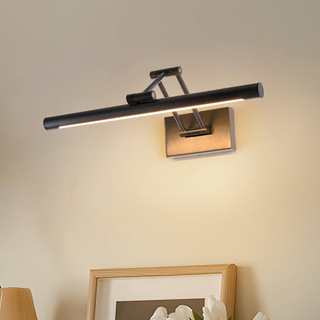 Black bar lit above two framed prints leaning on a shelf in a warm lit corner