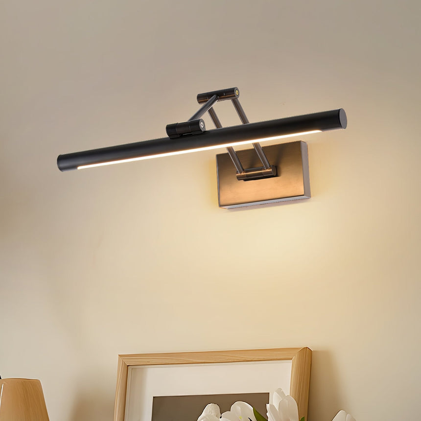 Black bar lit above two framed prints leaning on a shelf in a warm lit corner