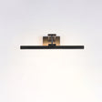 The shortest black bar lit on a pale wall, the beam spreading evenly below it