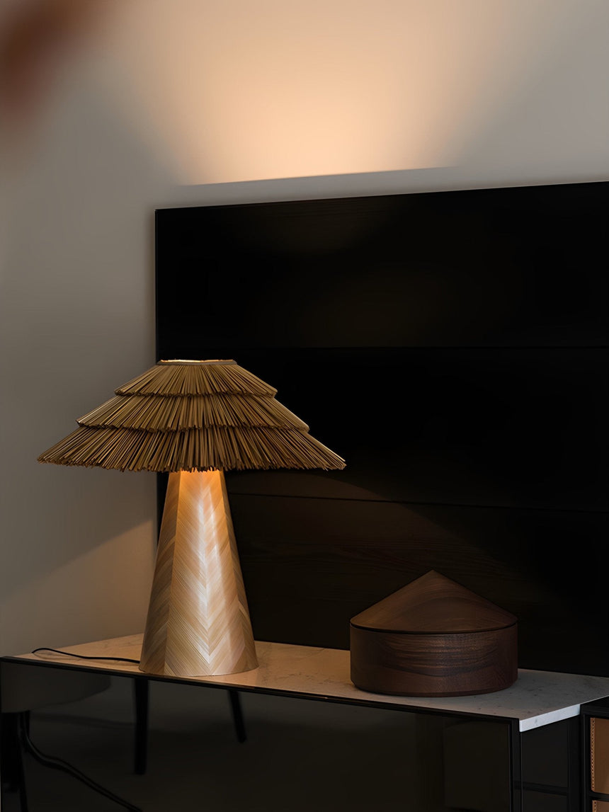 Boho table lamp lit on a console in a dim room beside a screen