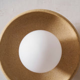 Close view of the opal globe set in the speckled sand glaze bowl