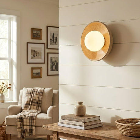 The sconce above a low console in a reading corner with an armchair and framed prints