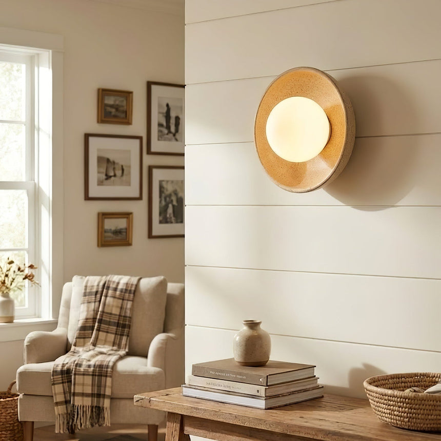 The sconce above a low console in a reading corner with an armchair and framed prints