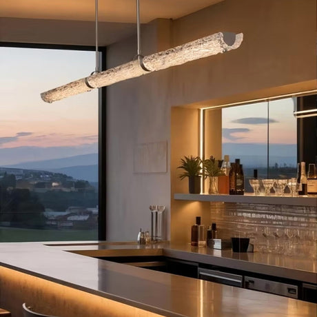 The glass branch lit above a bar counter with glasses on shelves