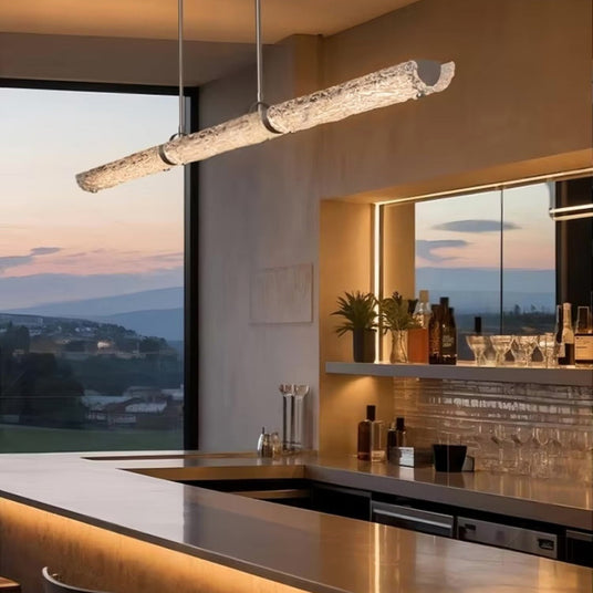 The glass branch lit above a bar counter with glasses on shelves