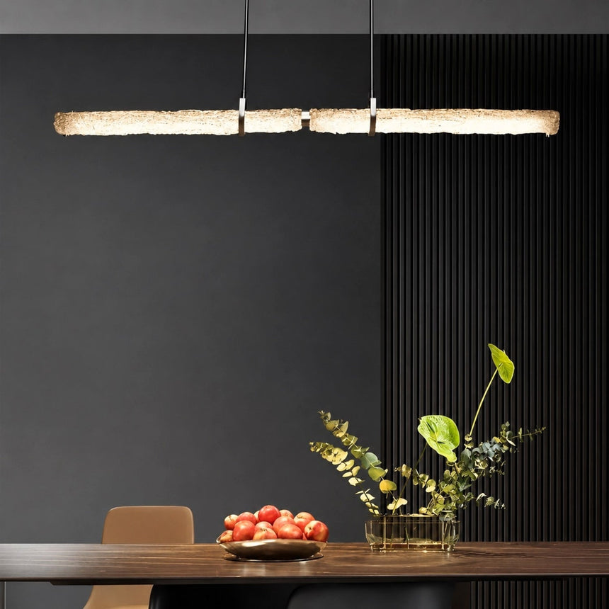 The textured glass branch lit above a dining table with a plant