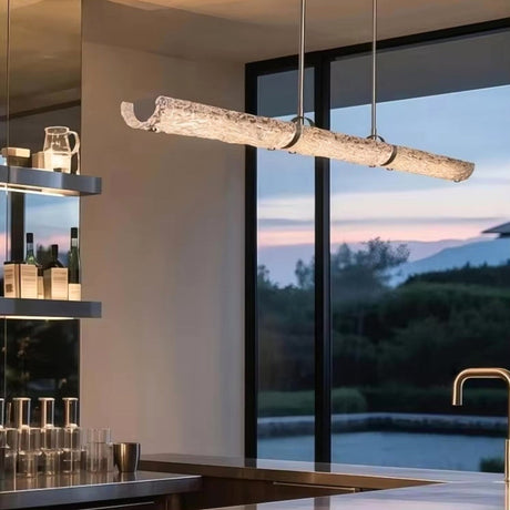 The glass branch lit above a kitchen counter in front of a window