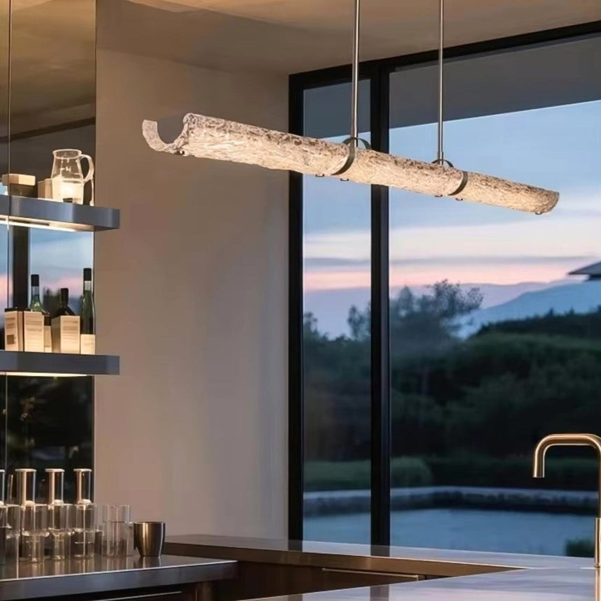 The glass branch lit above a kitchen counter in front of a window