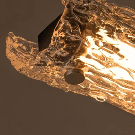 Close view of the lit glass showing the uneven surface of the branch