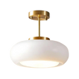 The white glass dome on its brass stem shown against a pale background
