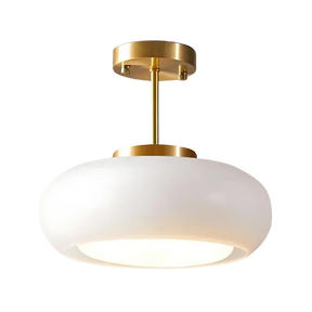 The white glass dome on its brass stem shown against a pale background