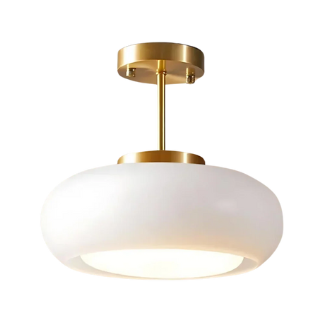 The white glass dome on its brass stem shown against a pale background