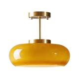 The yellow glass dome on its brass stem shown against a pale background