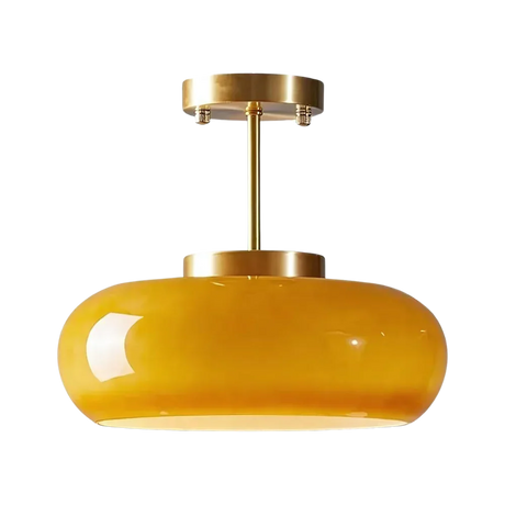 The yellow glass dome on its brass stem shown against a pale background