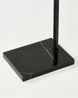 The black pole set into the same black marble slab, seen from the side