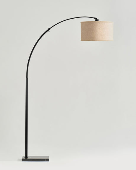 The black version of the arc stem holding an oatmeal linen drum shade
