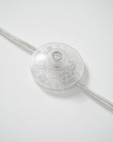 The inline foot switch on the cord, a flat disc pressed with one foot