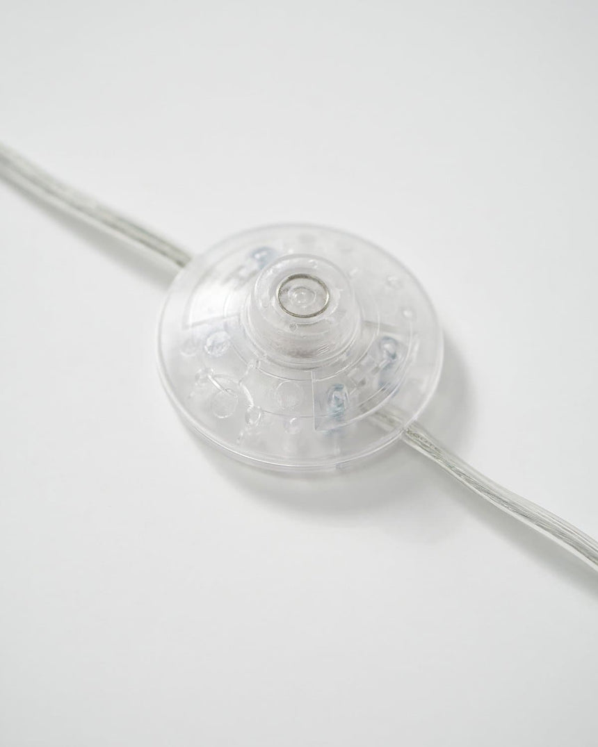 The inline foot switch on the cord, a flat disc pressed with one foot