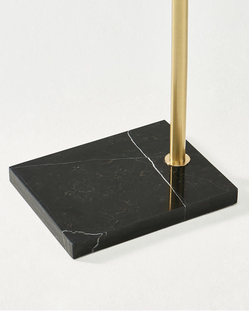The brass pole set into a black marble slab with a pale vein running through