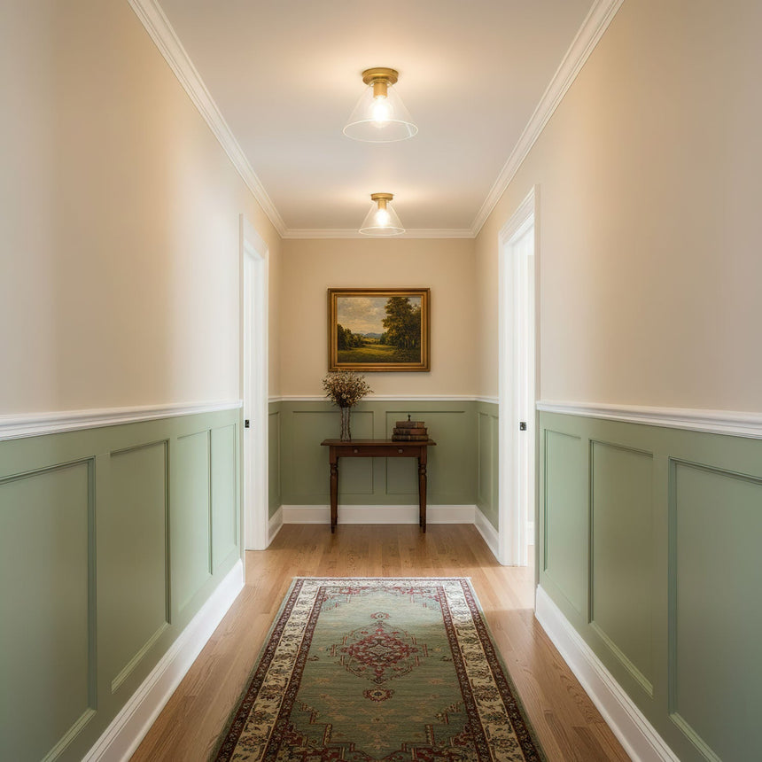 Brass ceiling lights along a corridor with green paneling and a runner