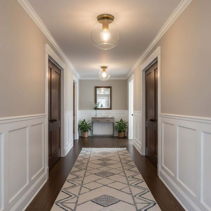 Brass ceiling lights in a hallway with wainscoting and a tiled floor