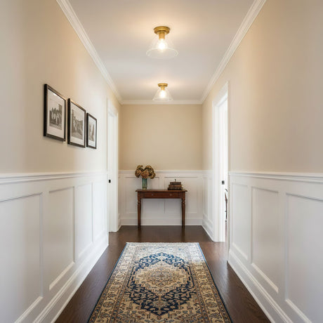 Brass ceiling light in a hallway with framed prints and a console table