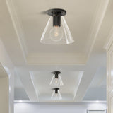 Black ceiling lights with cone shades in a white corridor with a stepped ceiling