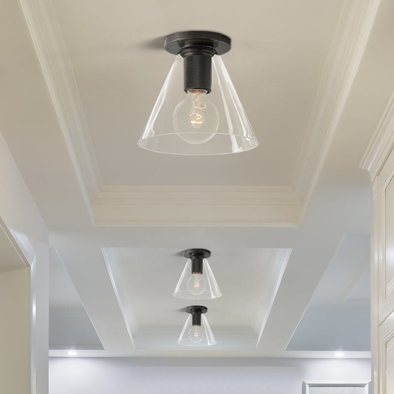 Black ceiling lights with cone shades in a white corridor with a stepped ceiling