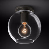 Black ceiling light with a clear globe shade against a dark backdrop