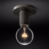 Black ceiling light with an exposed filament bulb against a dark backdrop