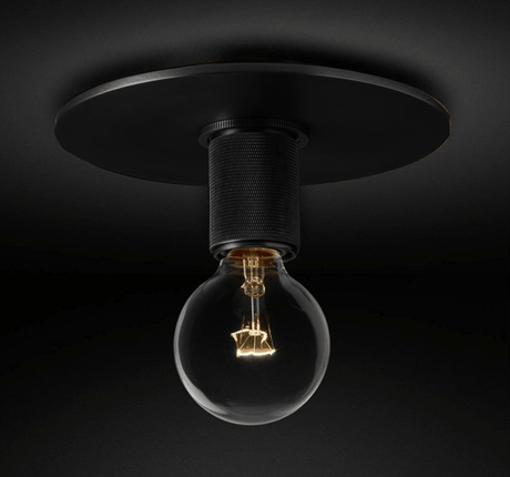Black ceiling light seen from the side with a bare filament bulb
