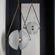 The brass frame and split glass disc lit against a dark painted wall