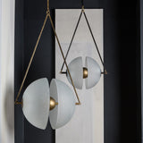The brass frame and split glass disc lit against a dark painted wall