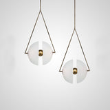 Two framed glass discs lit side by side on a pale wall in a bright room