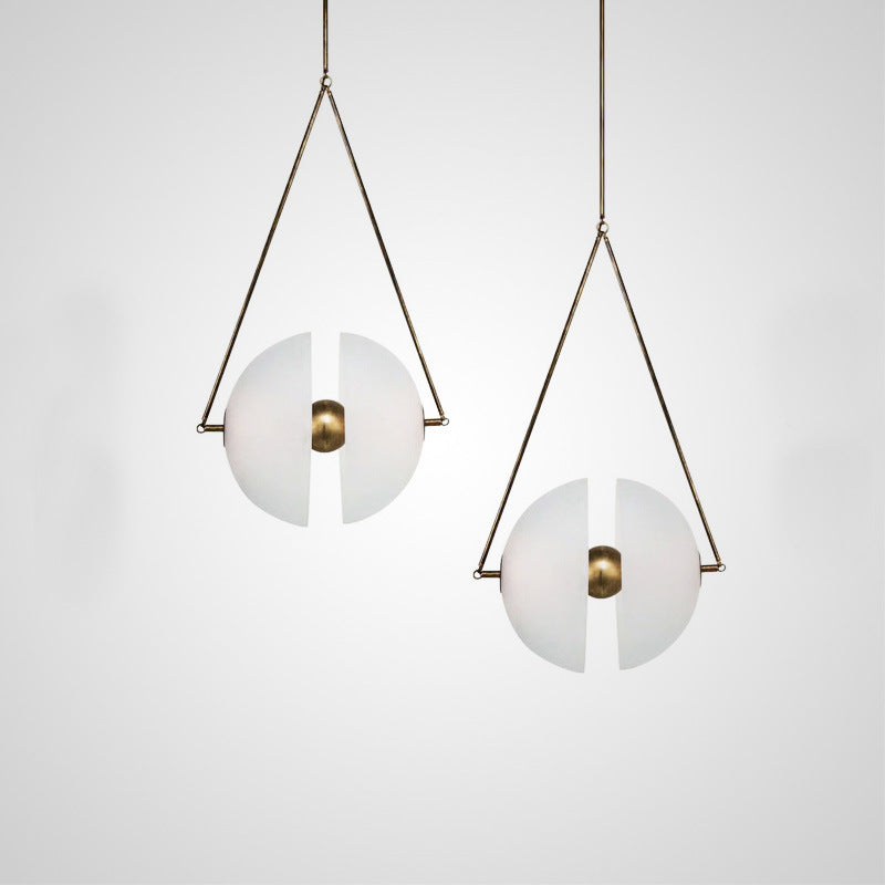 Two framed glass discs lit side by side on a pale wall in a bright room