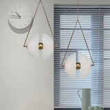 Two framed glass discs lit on a pale wall beside a round clock