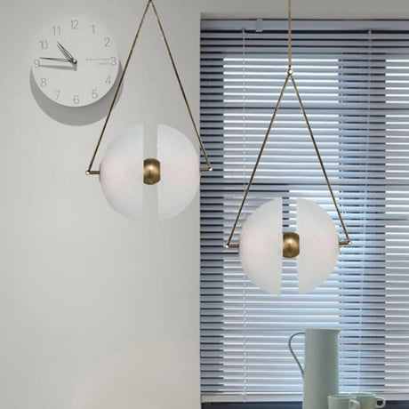 Two framed glass discs lit on a pale wall beside a round clock