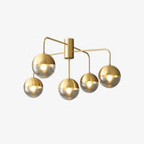 Five globe brass ceiling light seen from the side on a pale backdrop