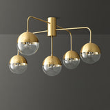 Five globe brass ceiling light lit against a gray background