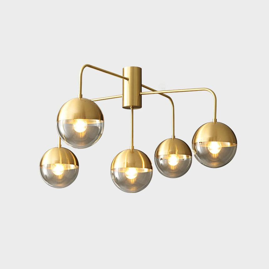Five globe brass ceiling light seen straight on against a pale backdrop