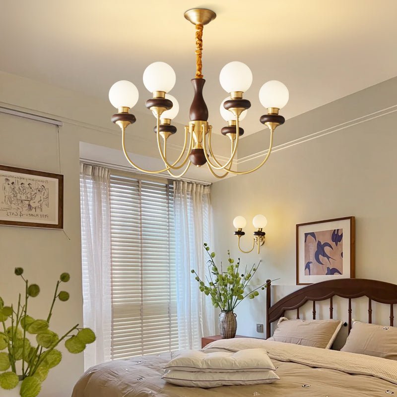 The globes lit in a bedroom above a made bed beside a window blind